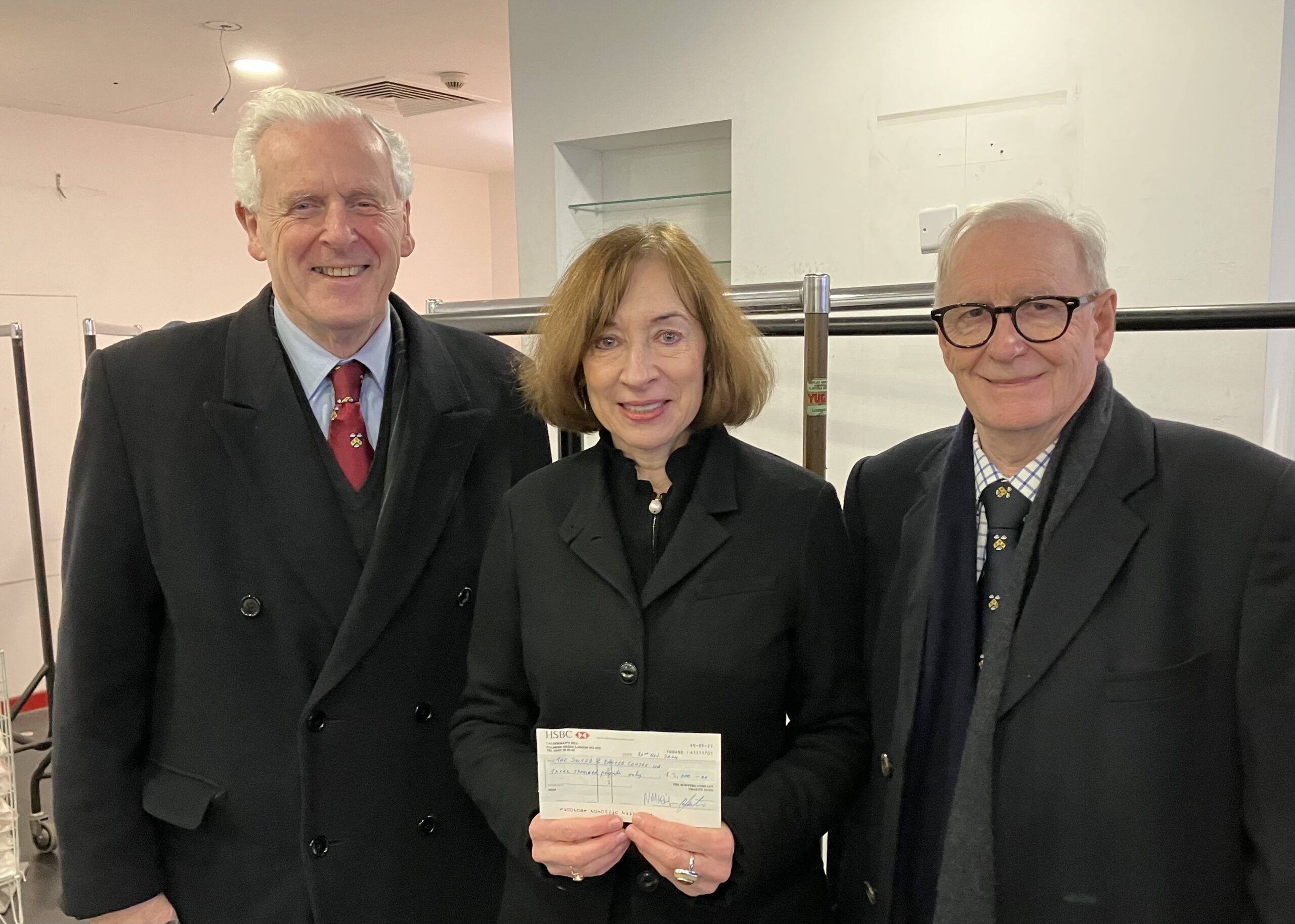 2 Men and 1 Woman pose for photo with a cheque.